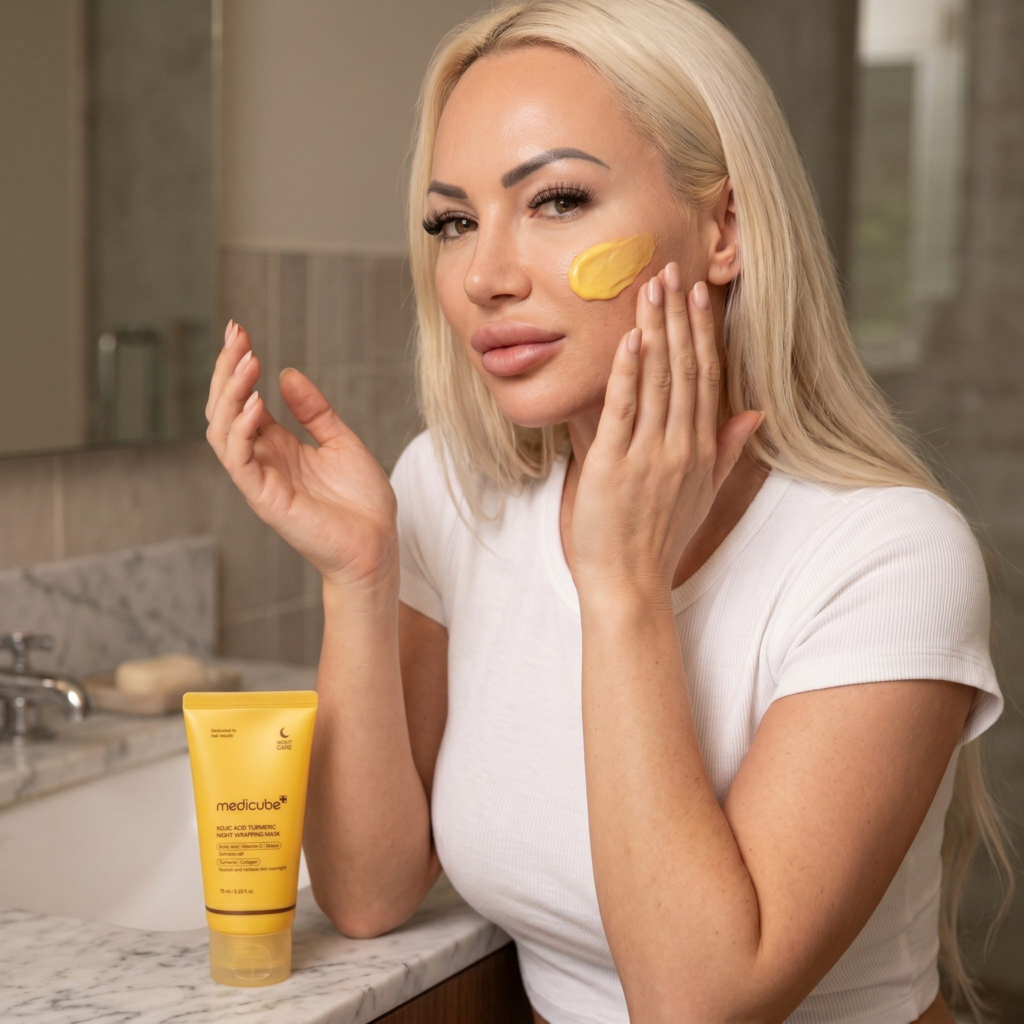 Kobieta nakłada Medicube Kojic Acid Turmeric Night Wrapping Mask na twarz – koreańska maska nocna z kurkumą, witaminą C i retinolem do skóry z przebarwieniami